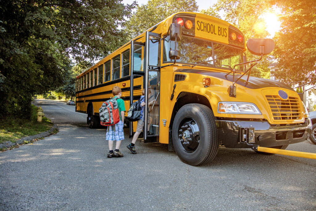 Children wait for school buses at bus stops